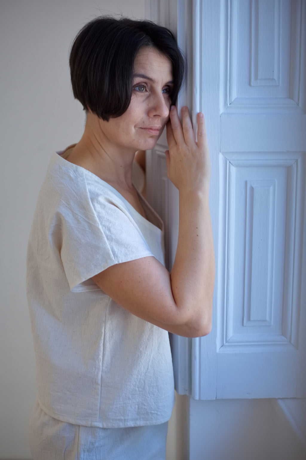Közeli kép egy modellről, amely a limitált kiadású, nyersfehér No 3 khadi kimono felső nyakkivágását és vállredőzését mutatja be.