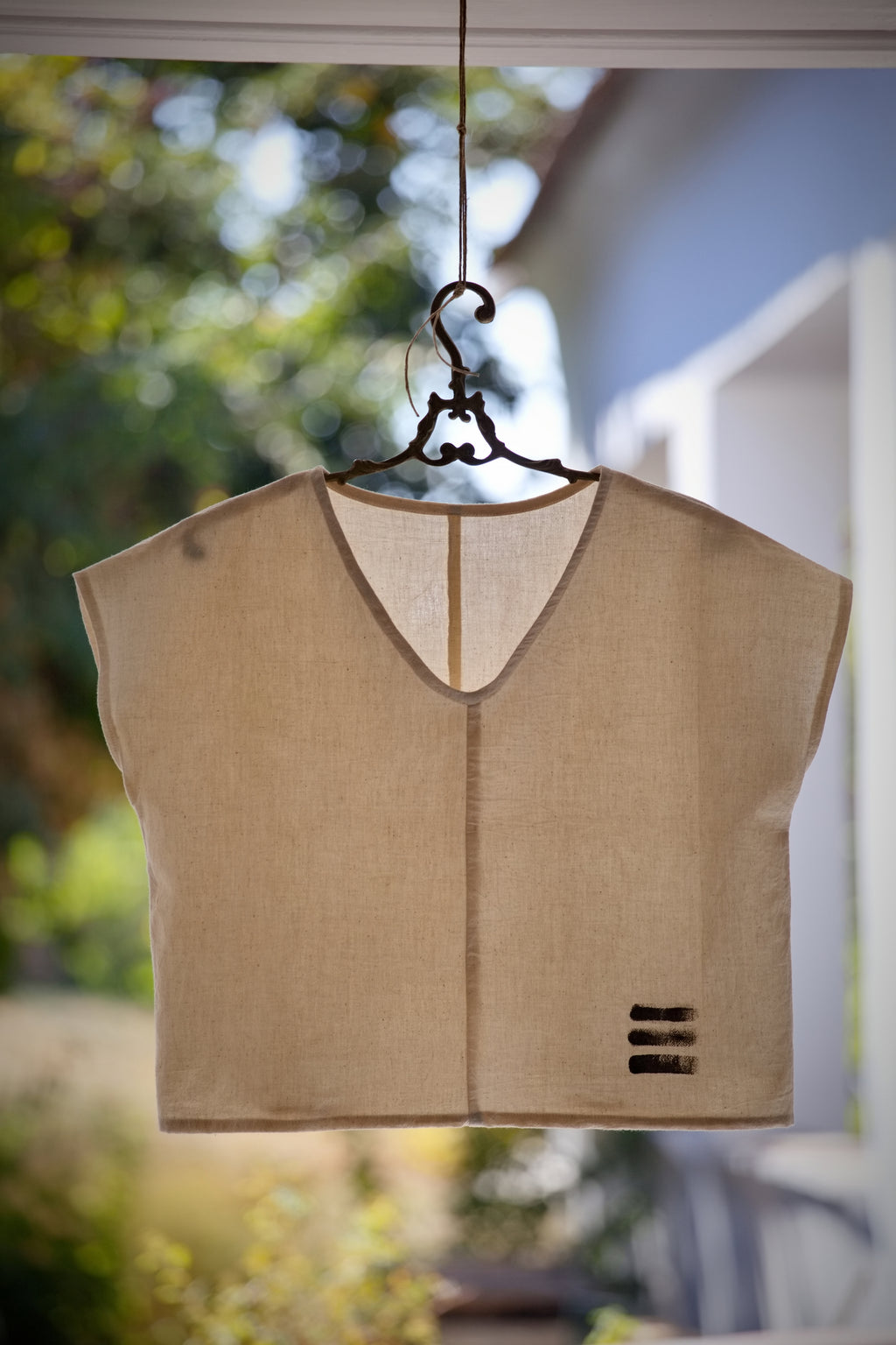 Limitált kiadású, sorszámozott, nyersfehér színű, kézzel szőtt No 3 khadi kimono felső egy antik vállfára akasztva.