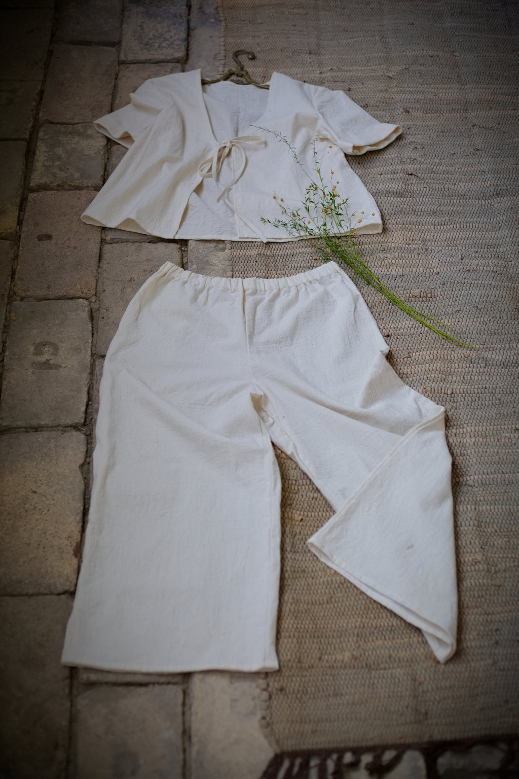Felülnézeti (flat lay) kép a limitált kiadású, kézzel szőtt No 6 bő szárú khadi nadrágról, a hozzáillő megkötős inggel szettként elrendezve.