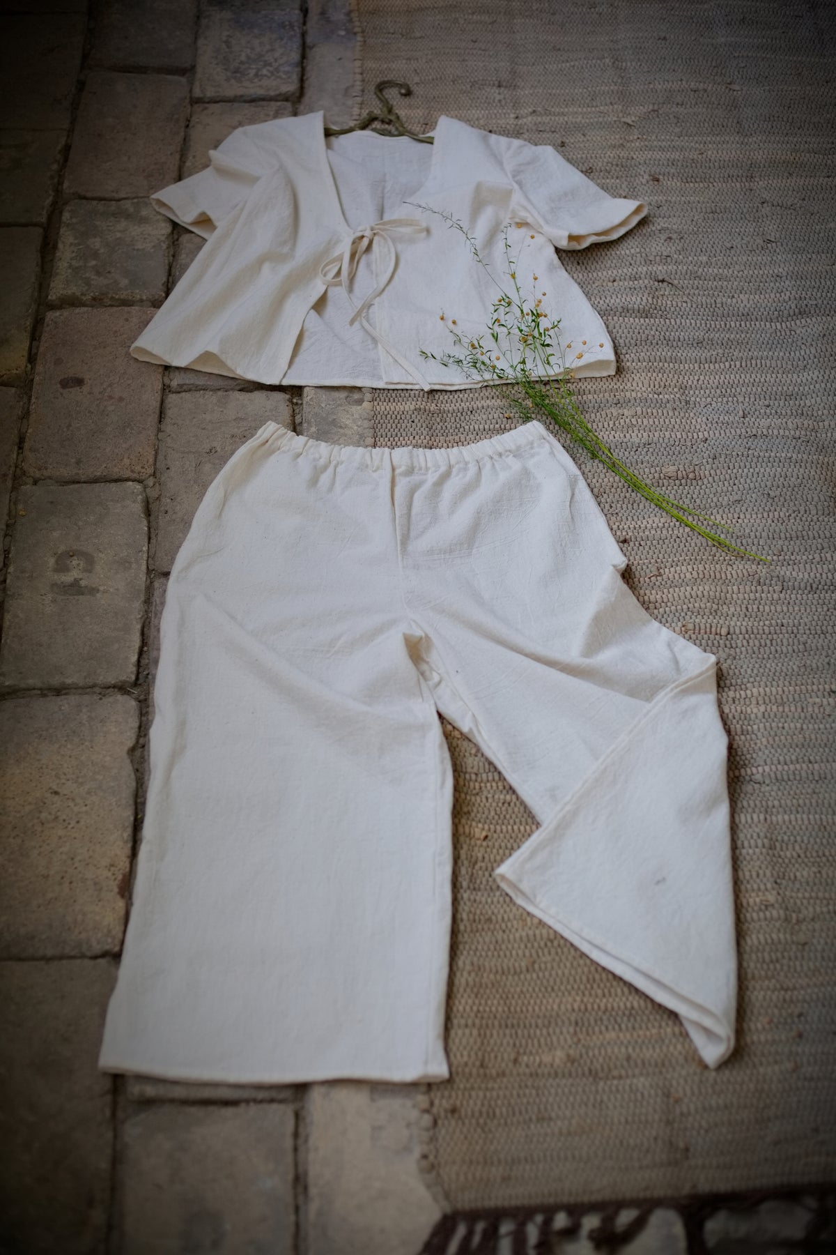 Felülnézeti (flat lay) kép a limitált kiadású, kézzel szőtt No 6 bő szárú khadi nadrágról, a hozzáillő megkötős inggel szettként elrendezve.
