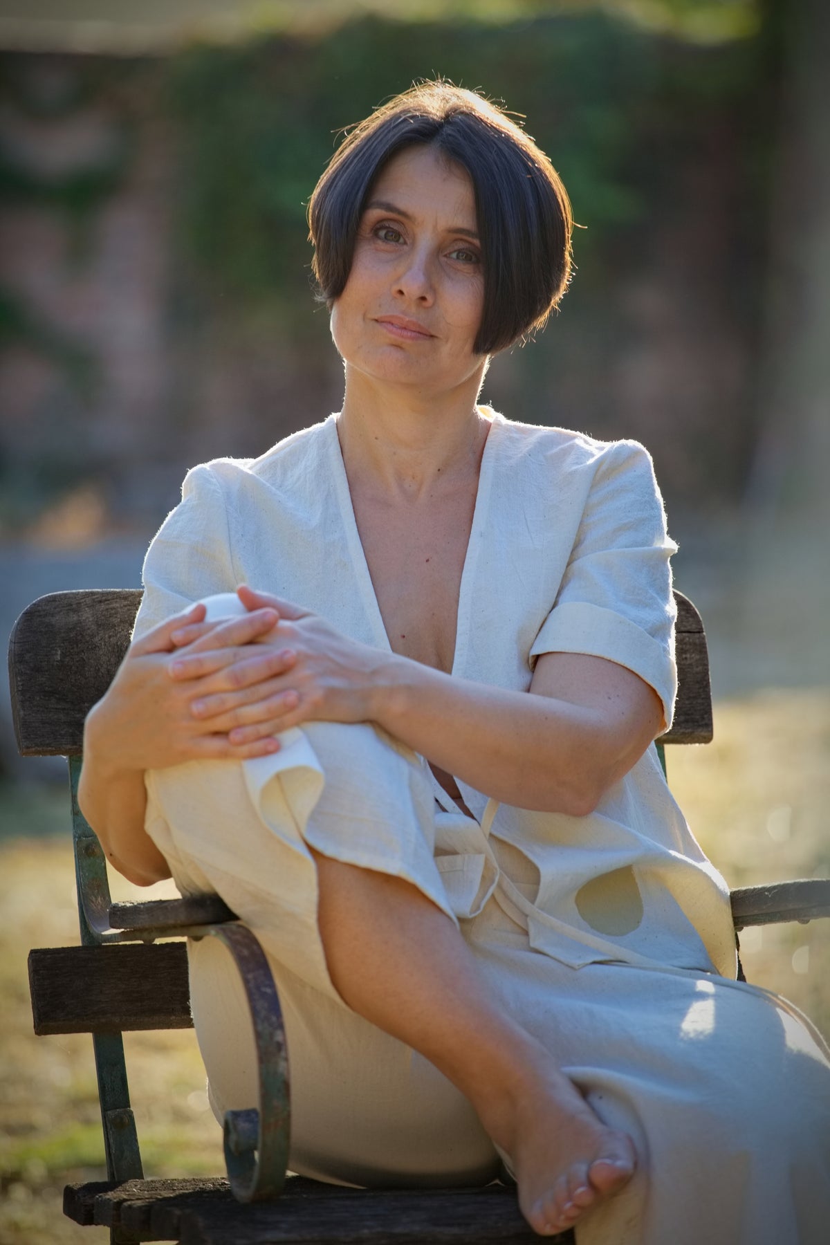 Életkép (lifestyle portré) egy rusztikus székben ülő modellről, aki a limitált kiadású, kézzel szőtt No 8 elöl megkötős khadi inget viseli.